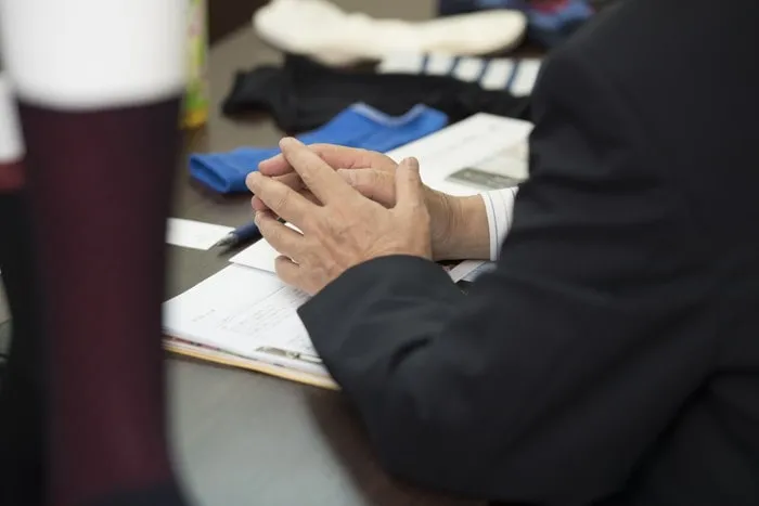 椅子に座って手を組むサラリーマン